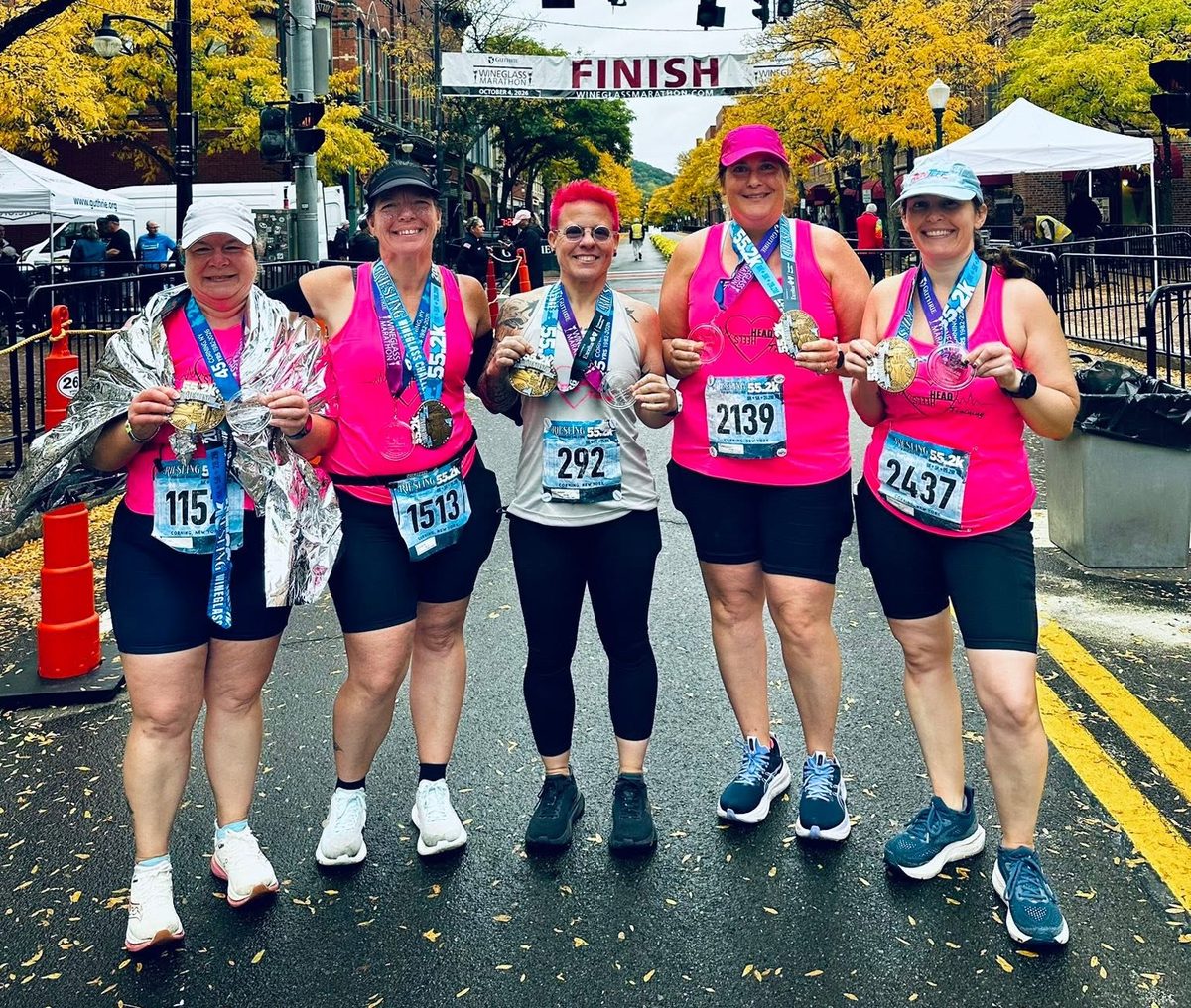 Head Over Heels runners with their medals at the Wineglass Marathon finish line in Corning, NY